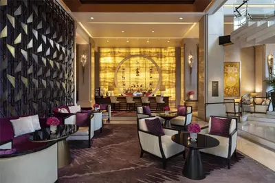 a lobby of a hotel with chairs and tables at Siam Kempinski Hotel Bangkok in Bangkok