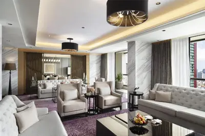a living room with couches and a dining room at Siam Kempinski Hotel Bangkok in Bangkok