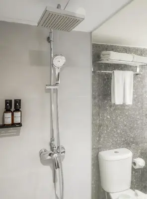 a shower in a bathroom with a toilet at Cross Vibe Bangkok Srinakarin in Bangkok