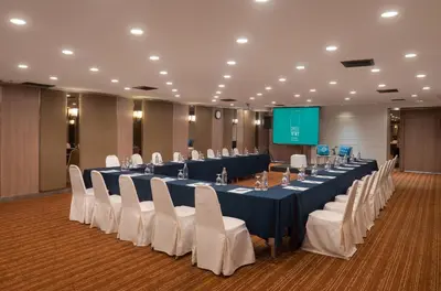 a conference room with a long table and white chairs at Cross Vibe Bangkok Srinakarin in Bangkok
