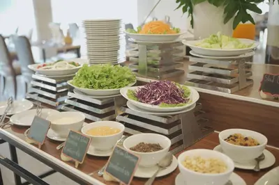 a buffet with bowls and plates of food on a table at Cross Vibe Bangkok Srinakarin in Bangkok