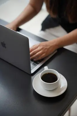 a cup of coffee and a laptop on a table at Cross Vibe Bangkok Srinakarin in Bangkok