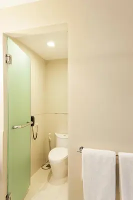 a bathroom with a toilet and white towels at Hotel Solo, Sukhumvit 2, Bangkok - SHA Extra Plus in Bangkok