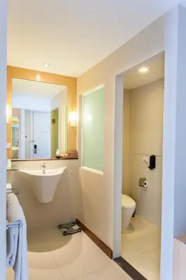 a bathroom with a sink and a toilet and a mirror at Hotel Solo, Sukhumvit 2, Bangkok - SHA Extra Plus in Bangkok