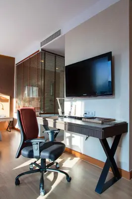 a room with a desk with a television and a chair at Hotel Solo, Sukhumvit 2, Bangkok - SHA Extra Plus in Bangkok