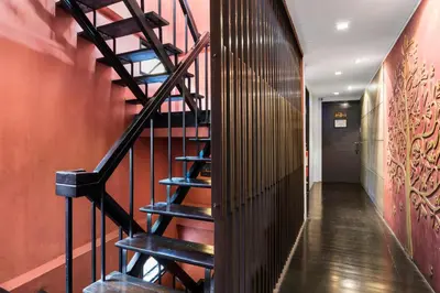 a spiral staircase in a hallway with red walls at Nappark Hostel @Khao San in Bangkok