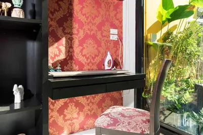 a chair sitting next to a window with a wall at Nappark Hostel @Khao San in Bangkok