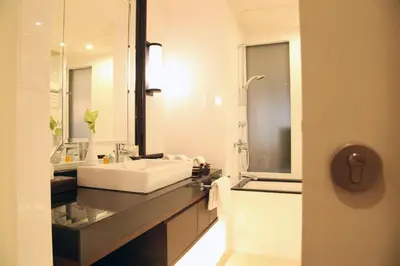 a bathroom with a white sink and a mirror at At 21 Saladaeng in Bangkok