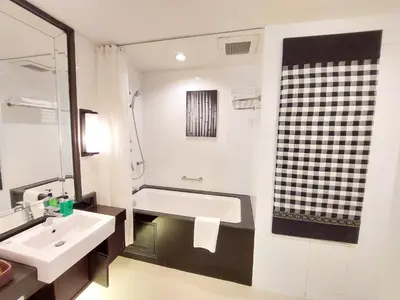 a bathroom with a bath tub and a sink at At 21 Saladaeng in Bangkok