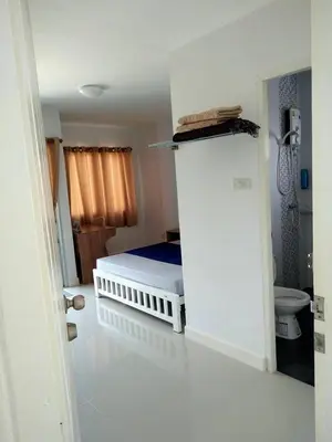 a small bedroom with a bed and a toilet at Little Home in Nonthaburi