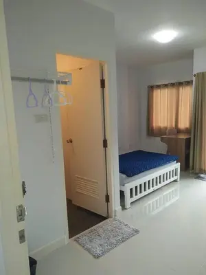 a small room with a bed and a door to a bedroom at Little Home in Nonthaburi