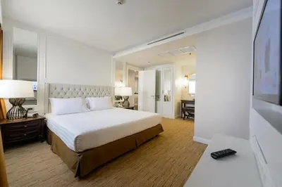 a hotel room with a bed and a desk and a bedroom at Bliston Suwan Park View in Bangkok
