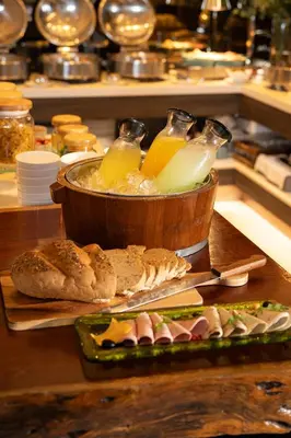 a buffet with a bowl of food and a plate of food at Bliston Suwan Park View in Bangkok