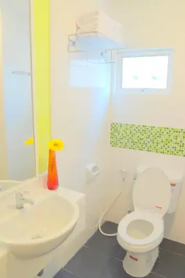 a bathroom with a white toilet and a sink at The Inn Saladaeng in Bangkok