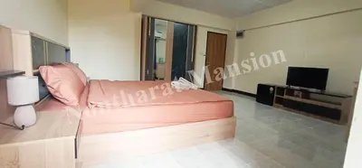 a living room with a couch and a television at Nontharat Mansion in Nonthaburi