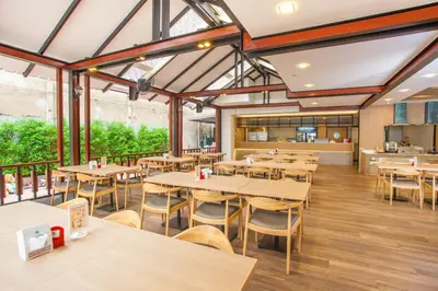 an empty restaurant with wooden tables and chairs at New Siam Palace Ville Hotel in Bangkok