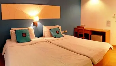 a bedroom with a large white bed with two pillows at Nantra de Comfort in Bangkok