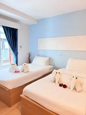 two beds with stuffed animals on them in a room at Nantra de Comfort in Bangkok