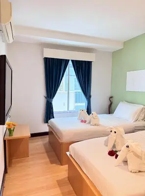 a bedroom with two beds with stuffed animals on them at Nantra de Comfort in Bangkok