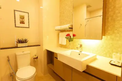 a bathroom with a white toilet and a sink at Green Point Residence Hotel in Bangkok