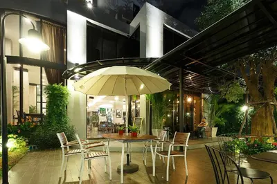 a patio with a table and chairs and an umbrella at Green Point Residence Hotel in Bangkok