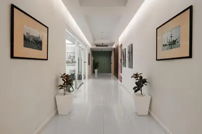 a hallway with potted plants and paintings on the walls at The Legacy Hotel Nana Sukhumvit, Aspira Collection in Bangkok