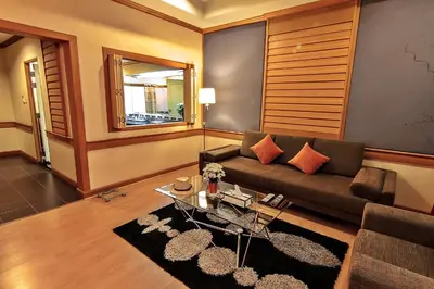 a living room with a couch and a table at Bossotel Bangkok in Bangkok