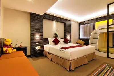 a hotel room with a large bed and a teddy bear at Bossotel Bangkok in Bangkok