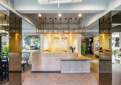a lobby of a store with a counter and chairs at Ton Aor Place Hotel in Bangkok