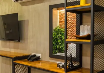 a mirror on a shelf in a room at Ton Aor Place Hotel in Bangkok