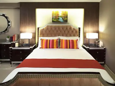 a bedroom with a large bed with two lamps at Ton Aor Place Hotel in Bangkok