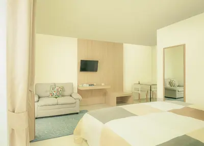 a hotel room with a bed and a couch at Baansuanprannok Hotel in Bangkok