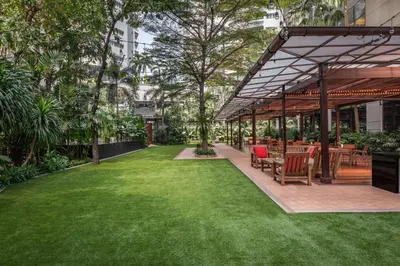 a garden with tables and chairs in a building at Marriott Executive Apartments Sukhumvit Park, Bangkok in Bangkok