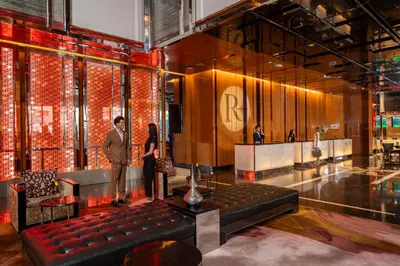 a man and a woman standing in a lobby at Renaissance Bangkok Ratchaprasong Hotel by Marriott in Bangkok