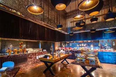 a dining room with tables and a bar at Renaissance Bangkok Ratchaprasong Hotel by Marriott in Bangkok