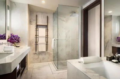 a bathroom with a shower and a sink and a tub at Anantara Riverside Bangkok Resort in Bangkok
