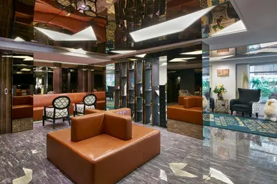 a lobby with couches and chairs in a building at Sora Hotel Silom in Bangkok