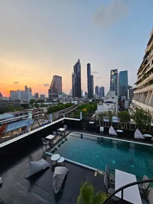 a swimming pool on top of a building with a city skyline at Sora Hotel Silom in Bangkok
