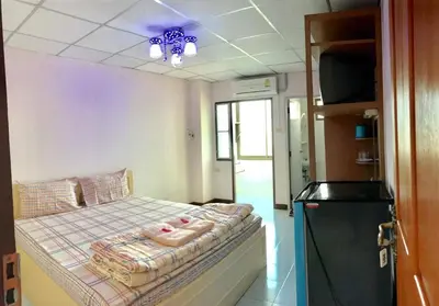 a small bedroom with a bed with a blue ceiling at Tat Hotel in Bangkok