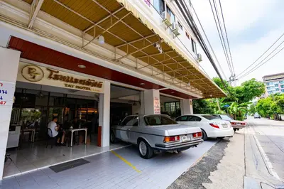 two cars parked in front of a building at Tat Hotel in Bangkok