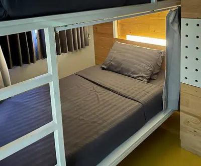 a bunk bed in a room with a pillow and a bed at PAMAhouse Boutique Hostel in Bangkok