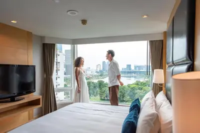 a bride and groom standing in a hotel room with a window at Sora Resort & Suites Sukhumvit in Bangkok
