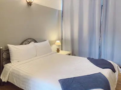 a bedroom with a large white bed and a window at Pillow & Bread Hostel in Bangkok