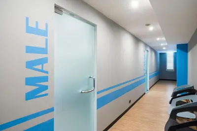 an office corridor with a door and chairs at Evergreen Place Siam by UHG in Bangkok