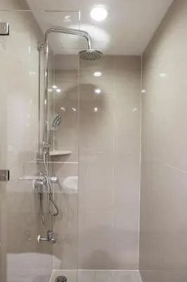 a shower with a glass door in a bathroom at Evergreen Place Siam by UHG in Bangkok