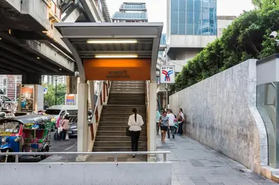 a woman walking down a stairs in a city at Evergreen Place Siam by UHG in Bangkok
