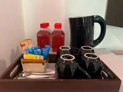 a tray with four bottles of juice and a coffee maker at Northgate Ratchayothin in Bangkok