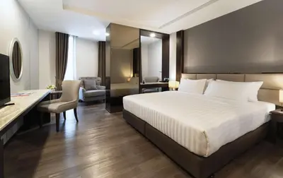 a bedroom with a large white bed and a desk at SureStay Plus by Best Western Sukhumvit 2 in Bangkok