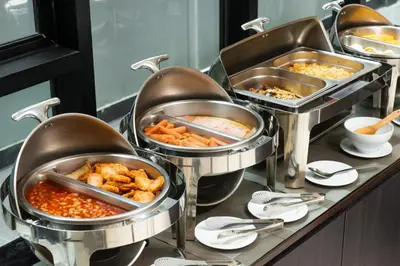a buffet line with several trays of food at SureStay Plus by Best Western Sukhumvit 2 in Bangkok