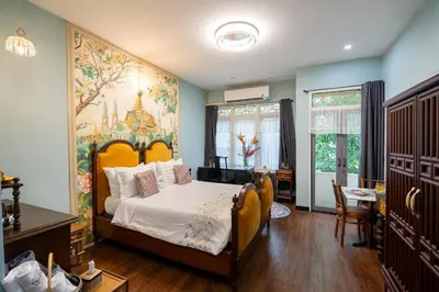 a bedroom with a bed and a painting on the wall at The Unforgotten B&B in Bangkok
